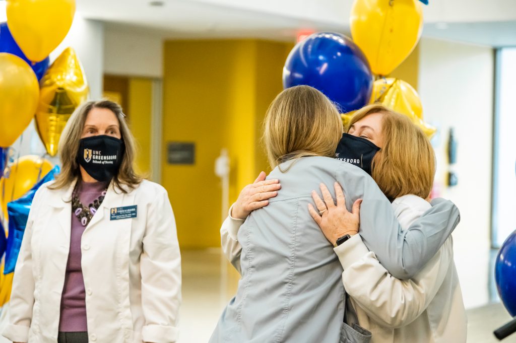 A UNC Greensboro School of Nursing student hugs a faculty member.