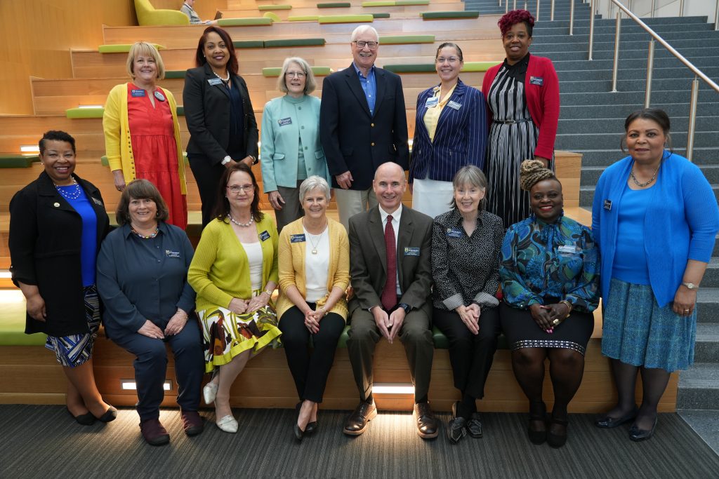 Members of the UNC Greensboro School of Nursing advisory board pose for a photo inside the Nursing and Instructional Building.