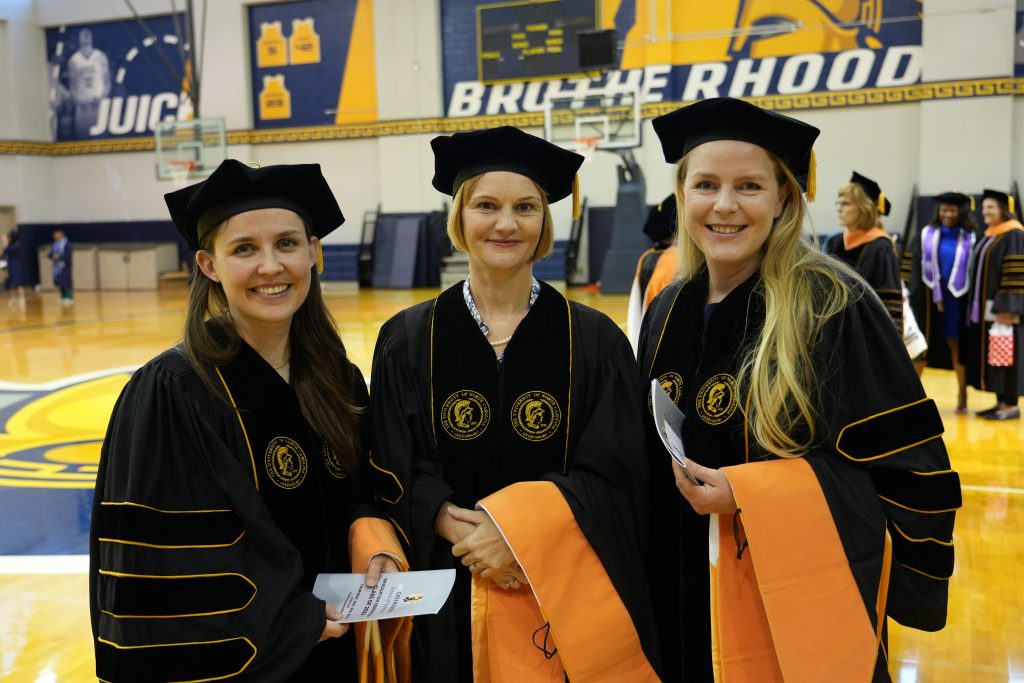 UNC Greensboro graduates Susan Fischer, Kathrin Thormann, and Karin Ritschard pose for a photograph at graduation.