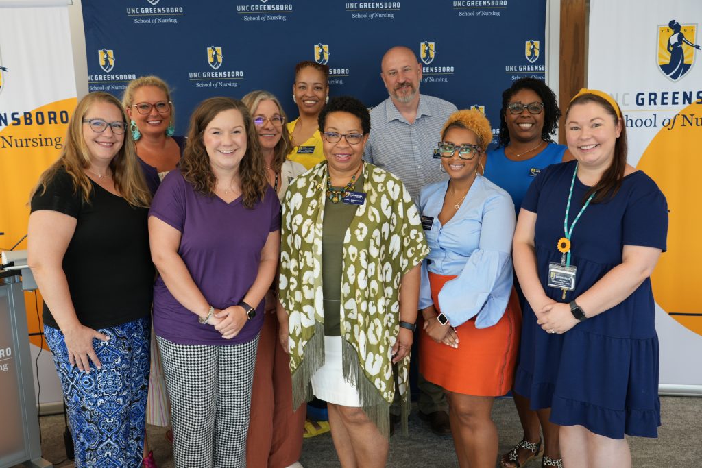 UNC Greensboro School of Nursing dean Debra J. Barksdale poses for a photograph with new faculty members.