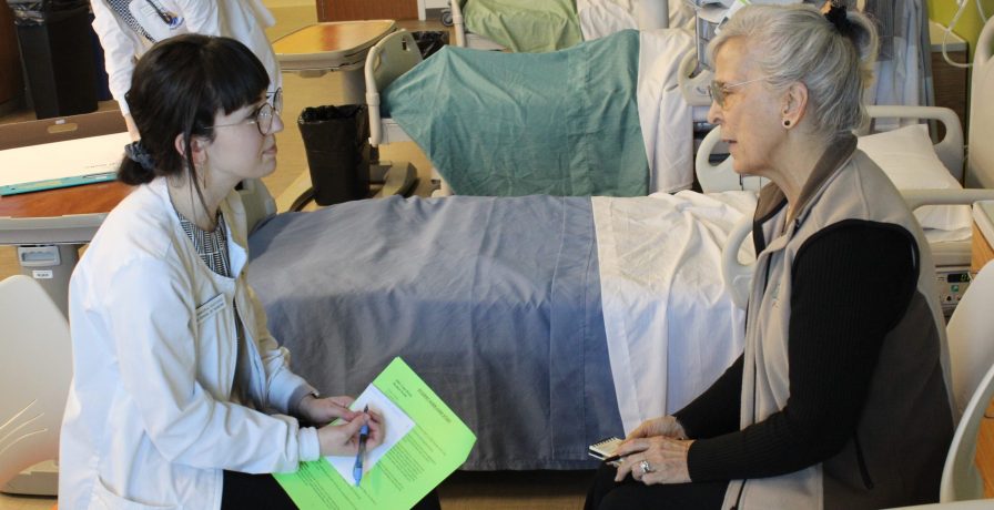 A UNC Greensboro School of Nursing BSN student speaks with an older patient during a simulation at the Union Square Campus.