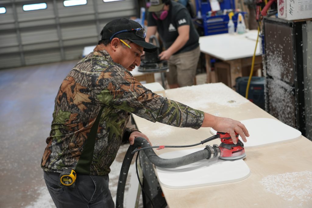 A Mission Mobile Medical worker uses a sander in the workshop.