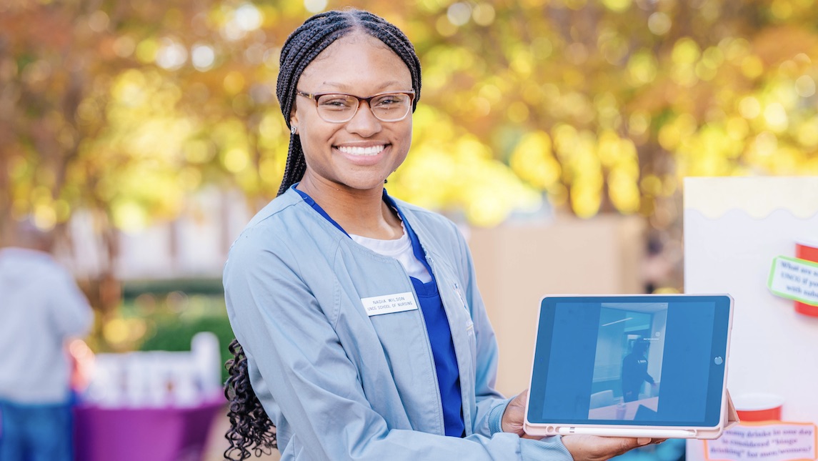 Nursing student holding an iPad.