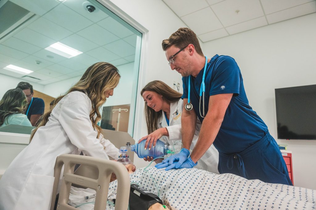 Dille Student Support Fund recipients Huong Thuy Ka’24, Lyndsey Dark ’24, and Zack Wiggins ’25, conduct a practice drill in the UNC Greensboro School of Nursing clinical laboratory.