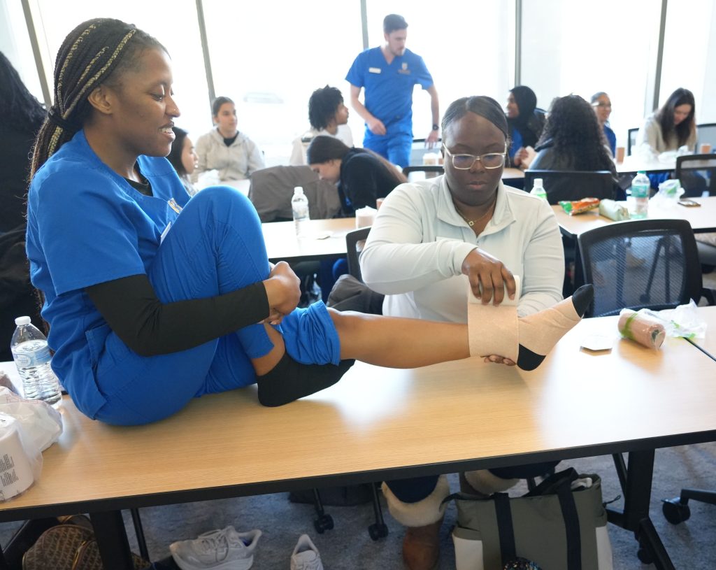 Nursing students work together on bandaging techniques